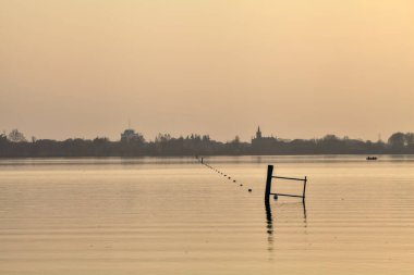 Gün batımında göl ve karşı kıyıda bir kasaba.