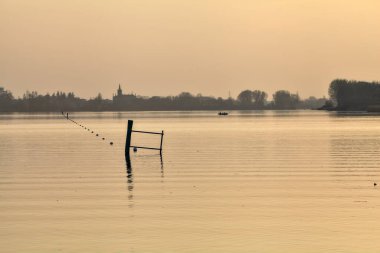 Gün batımında göl ve karşı kıyıda bir kasaba.