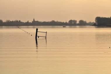Gün batımında göl ve karşı kıyıda bir kasaba.