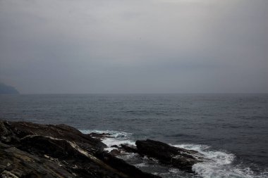 Yağmurlu ve bulutlu bir günde deniz kenarında uçurum