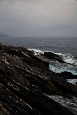Yağmurlu ve bulutlu bir günde deniz kenarında uçurum