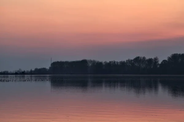 Jezioro Zachodzie Słońca Lasem Oddali Niebo Skulone Wodzie — Zdjęcie stockowe