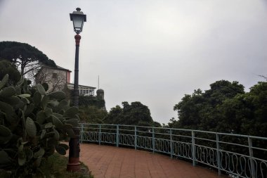 Bulutlu bir günde, bir İtalyan kasabasının parkında panoramik izler.