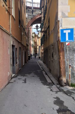 Bulutlu bir günde yüksek binalarla çevrili dar bir sokak.