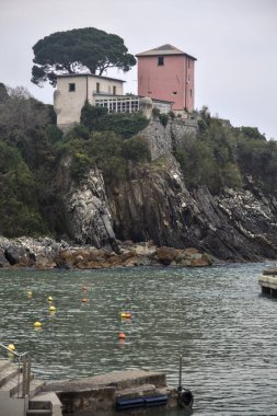 Bulutlu bir günde tepesinde bir ev olan uçurumlar tarafından kapatılmış körfez.