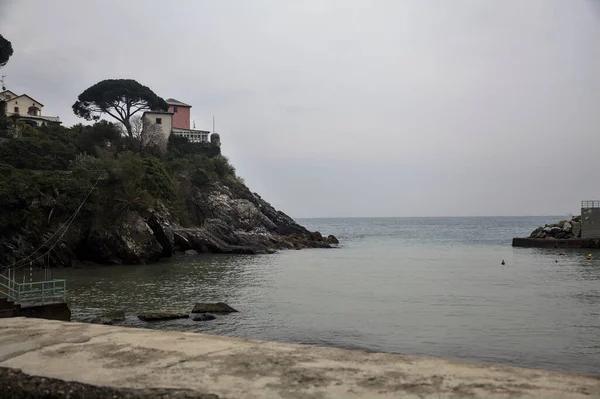 Bulutlu bir günde tepesinde bir ev olan uçurumlar tarafından kapatılmış körfez.