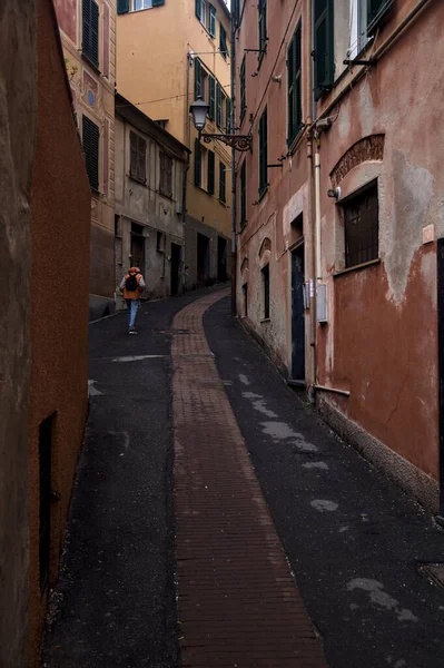 Bulutlu bir günde yüksek binalarla çevrili dar bir dağ yolu.