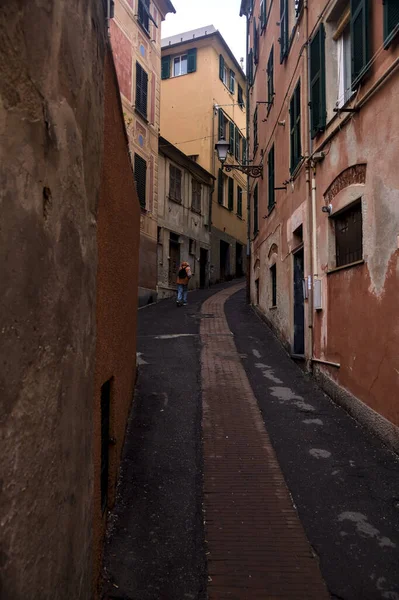 Bulutlu bir günde yüksek binalarla çevrili dar bir dağ yolu.