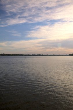 Gün batımında göl, gökte bulutlar