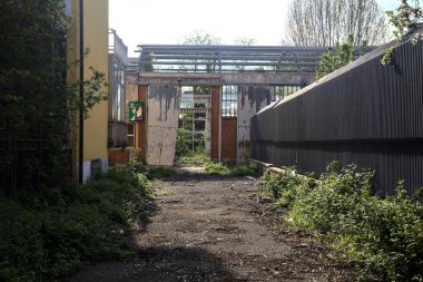 Gün batımında terk edilmiş bir fabrikanın girişinde.