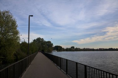 Alacakaranlıkta bir gölün kıyısındaki geçit.