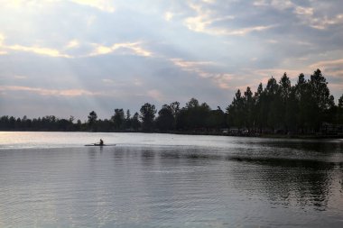 Gün batımında gölün üzerinde bir kano göründü.