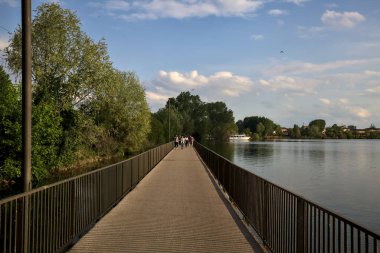 Gün batımında bir gölün üzerindeki köprüde