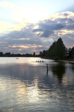 Gün batımında gölün üzerinde bir kano göründü.