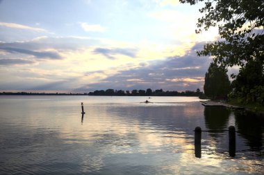 Gün batımında gölün üzerinde bir kano göründü.