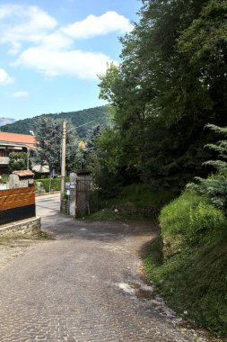 İnşaat alanının çitleriyle çevrili bir ormanda yokuş yukarı bir yoldan dön.