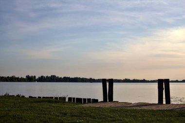 Gün batımında İtalya kırsalındaki göl kıyısında boş bir demirleme yeri.