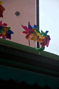 Yağmurlu bir günde arka planında iki bina olan bir çatıda fırıldak.