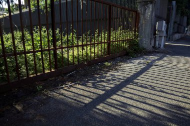 Paslı kapı ve gölgesi gün batımında yere düştü.