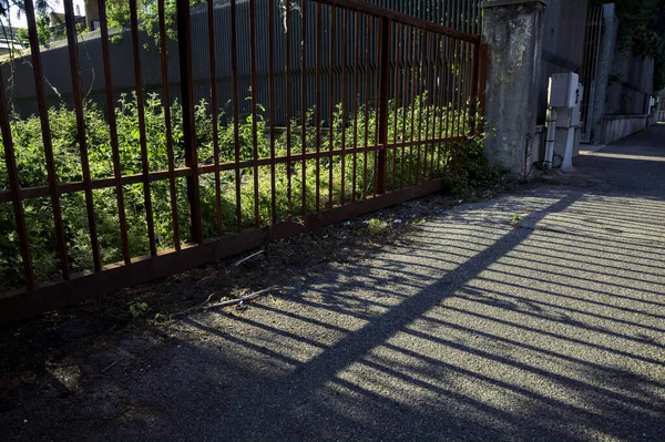 Paslı kapı ve gölgesi gün batımında yere düştü.