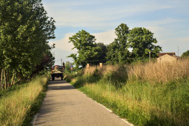 Gün batımında küçük bir köy yolunda traktör.