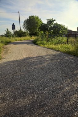 Gün batımında kırsalda bir kır evinin çitlerinin yanındaki patika.