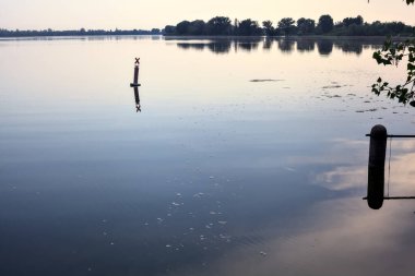 Gün batımında göl karşı kıyıda, uzakta.