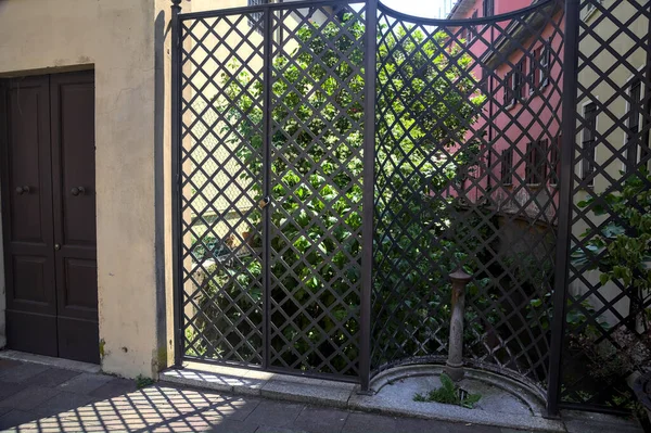 Régi Nyilvános Szökőkút Egy Kerítés Előtt Egy Sor Házzal Egy — Stock Fotó
