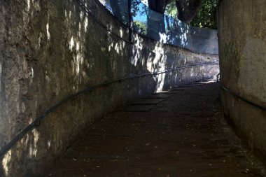 Güneşli bir günde gölgeli bir sokakta eğilmek