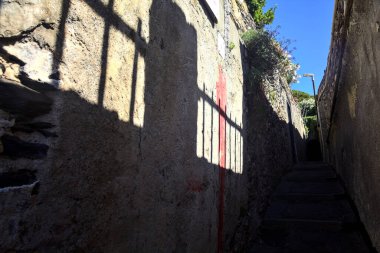 Güneşli bir günde merdivenli dar bir sokak.