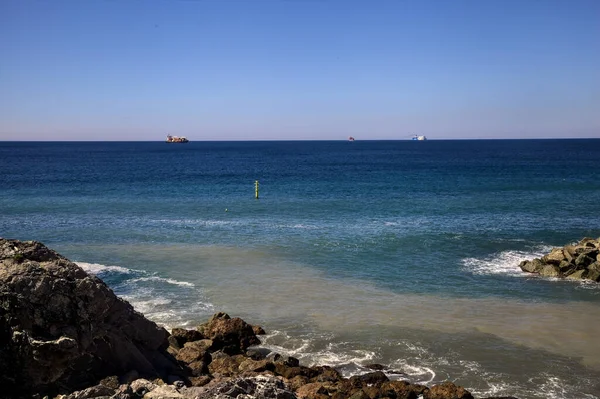 Mar Com Navios Carga Distância Emoldurado Por Penhasco Uma Praia — Fotografia de Stock