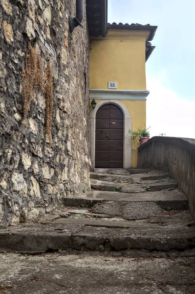 Stone staircase next to a wall that leads to a door of a house