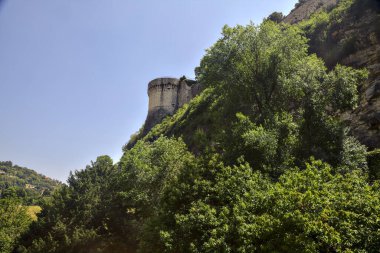 Part of a fortification on a cliff seen from a park below on a sunny day