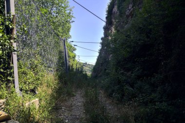 Terk edilmiş patika, uçurumun kenarındaki gölgede.