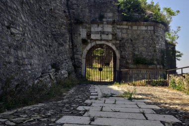 Kapalı bir kapıya giden yol ve uçurumun kenarında bir duvar.