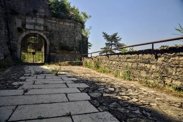 Paved Path Leads Closed Gate Wall Side Cliff — Fotografia de Stock