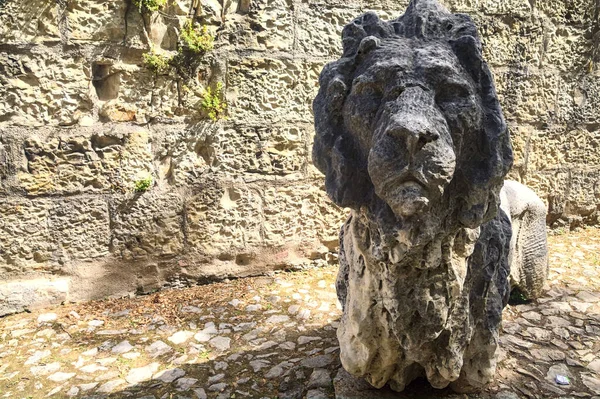 Statue of a lion next to a stone wall