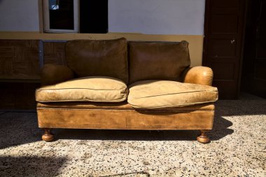 Kapının ve pencerenin yanındaki verandada bir kanepe.