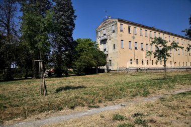 Güneşli bir günde uzaktan görülen yıpranmış cephelerle bina