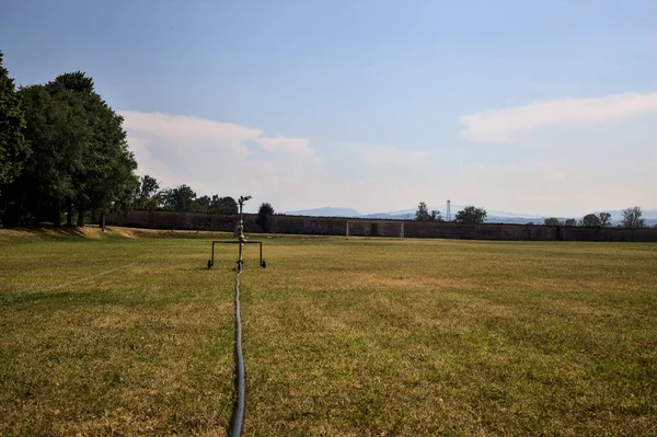 Sprinkler Edge Worn Football Field Sunny Day — Φωτογραφία Αρχείου