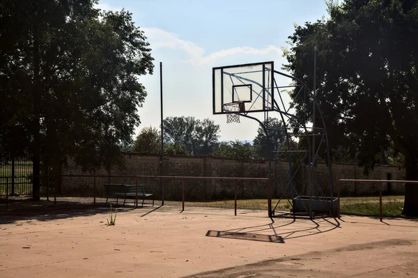 Güneşli Bir Günde Parmaklıkla Çevrili Boş Bir Basketbol Sahası — Stok fotoğraf