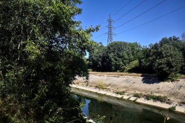 Diversionary channel with trees on a summer day in the italian countryside