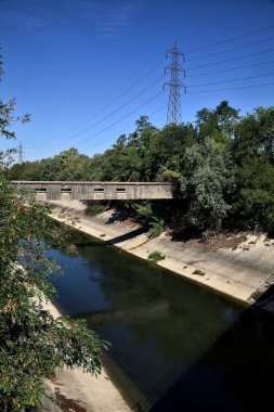 Diversionary channel with trees on a summer day in the italian countryside