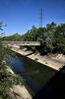 Diversionary channel with trees on a summer day in the italian countryside