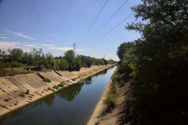Diversionary channel with trees on a summer day in the italian countryside