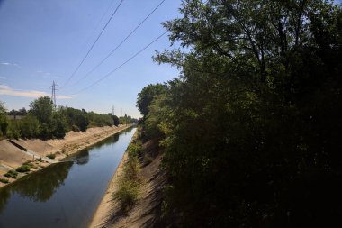 Diversionary channel with trees on a summer day in the italian countryside
