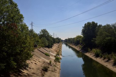 Diversionary channel with trees on a summer day in the italian countryside