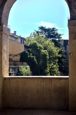Old porch with view on buildings and trees on a sunny day