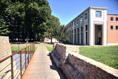 Passageway next to remains of an ancient building in a park on a sunny day