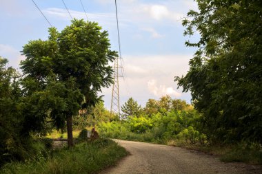 Bulutlu bir günde gün batımında İtalya kırsalında bir kasabada yol